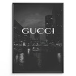 Load image into Gallery viewer, Fashion Plakat | Gucci Cityscape Black &amp; White Fashion Poster Plakaty.dk | Black and white poster with the Gucci logo over a night cityscape featuring tall buildings and water reflections.
