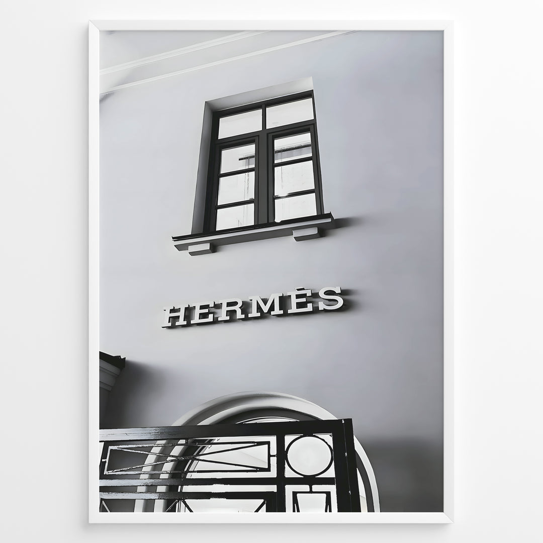 Fashion Plakat | Hermès Storefront Minimalist Poster – Black & White Fashion Wall Art Plakaty.dk | Black and white photo of the Hermès storefront with a clean minimalist facade, showing a window above the iconic logo and part of an ornate entryway gate.