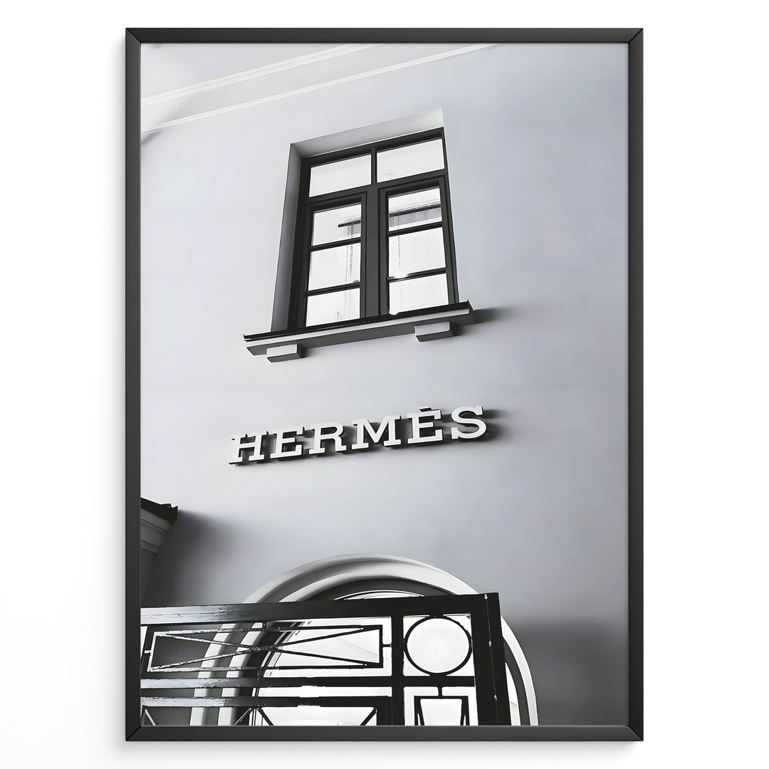 Fashion Plakat | Hermès Storefront Minimalist Poster – Black & White Fashion Wall Art Plakaty.dk | Black and white photo of the Hermès storefront with a clean minimalist facade, showing a window above the iconic logo and part of an ornate entryway gate.