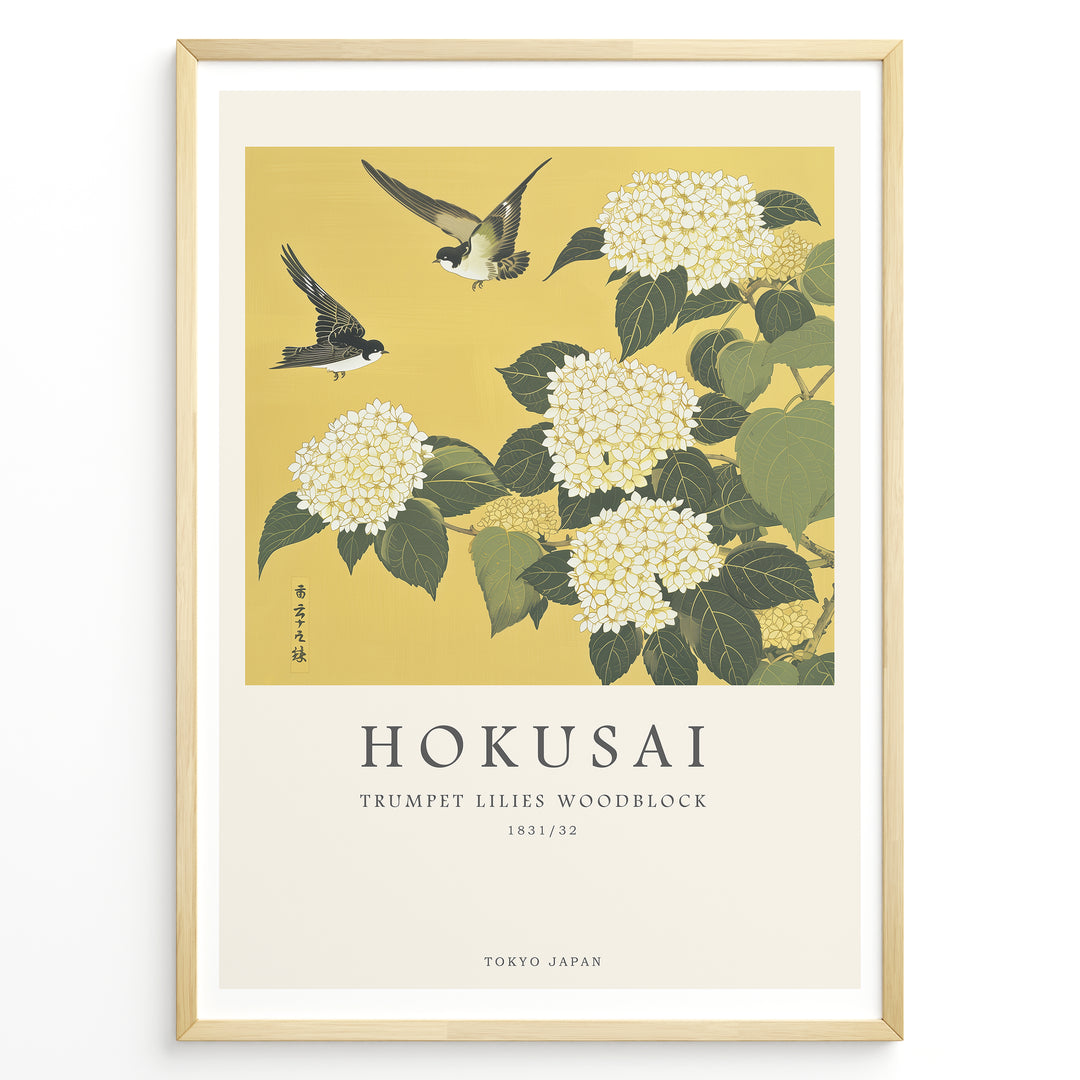 Japanske plakater | Japanese woodblock print of white trumpet lilies with green leaves and two sparrows flying against a yellow background, based on Hokusai’s  floral artwork.