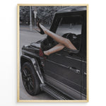 Load image into Gallery viewer, Fashion Plakat | Luxury Escape: Legs in High Heels Through Mercedes G-Wagon Window Plakaty.dk | Woman&#39;s legs in high heels sticking out of a Mercedes-Benz G-Wagon window in an urban street scene.

