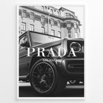 Load image into Gallery viewer, Fashion Plakat | Luxury Lifestyle: Mercedes G-Wagon x Prada Milano Wall Art Plakaty.dk | Black and white framed photo of a Mercedes G-Wagon with Prada Milano text overlay, parked in front of ornate historic buildings.
