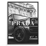 Load image into Gallery viewer, Fashion Plakat | Luxury Lifestyle: Mercedes G-Wagon x Prada Milano Wall Art Plakaty.dk | Black and white framed photo of a Mercedes G-Wagon with Prada Milano text overlay, parked in front of ornate historic buildings.
