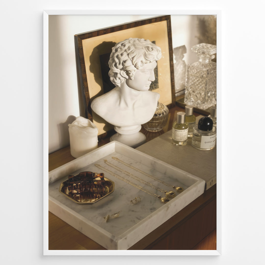 Fashion Plakat | Modern Vanity Scene with Sculptural Bust, Jewelry, and Perfume – Aesthetic Interior Print Plakaty.dk | Stylish vanity setup with a white classical bust, gold jewelry on a marble tray, designer perfumes, and crystal glassware in warm lighting.