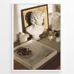 Load image into Gallery viewer, Fashion Plakat | Modern Vanity Scene with Sculptural Bust, Jewelry, and Perfume – Aesthetic Interior Print Plakaty.dk | Stylish vanity setup with a white classical bust, gold jewelry on a marble tray, designer perfumes, and crystal glassware in warm lighting.
