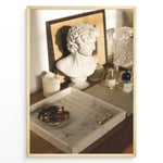 Load image into Gallery viewer, Fashion Plakat | Modern Vanity Scene with Sculptural Bust, Jewelry, and Perfume – Aesthetic Interior Print Plakaty.dk | Stylish vanity setup with a white classical bust, gold jewelry on a marble tray, designer perfumes, and crystal glassware in warm lighting.

