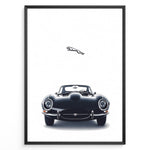 Load image into Gallery viewer, Framed minimalist poster of a black Jaguar E-Type classic sports car front view with the Jaguar leaping logo above on a white background.

