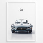 Load image into Gallery viewer, Framed minimalist poster of a silver Jaguar E-Type convertible classic car front view with Jaguar logo above on a white background.
