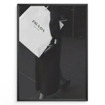 Load image into Gallery viewer, Fashion Plakat | Prada Shopping Bag Fashion Photography Wall Art Plakaty.dk | Black and white photo of a person holding a large Prada Milano shopping bag, dressed in elegant dark clothing.
