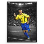 Load image into Gallery viewer, Ronaldo Nazário i den klassiske gule Brasilien-trøje med nummer 9, hvor han fejrer på fodboldbanen. Motivet har en sort-hvid stadionbaggrund med fremhævede brasilianske farver.
