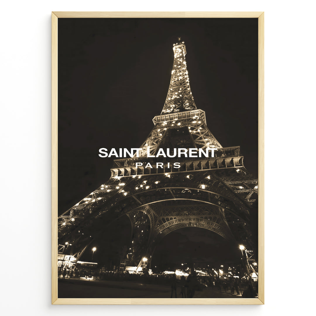 Fashion Plakat | Saint Laurent Eiffel Tower Night View – Paris Fashion Wall Art Plakaty.dk | Illuminated Eiffel Tower at night with "Saint Laurent Paris" logo centered in white text.