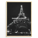 Load image into Gallery viewer, Fashion Plakat | Saint Laurent Eiffel Tower Poster – Black &amp; White Paris Fashion Print Plakaty.dk | Black and white photo of the Eiffel Tower illuminated at night with “Saint Laurent Paris” text overlay, capturing the essence of French fashion and elegance.
