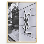 Load image into Gallery viewer, Fashion Plakat | Saint Laurent Paris Storefront – Monochrome Fashion Photography Plakaty.dk | Black and white image of a Saint Laurent Paris storefront featuring the reflective YSL logo on a textured exterior wall with modern architectural details.

