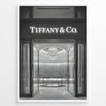 Load image into Gallery viewer, Fashion Plakat | Tiffany &amp; Co. Entrance – Luxury Jewelry Store Poster in Black &amp; White Plakaty.dk | Black and white photo of the Tiffany &amp; Co. boutique entrance with glass doors, a chandelier inside, and the illuminated brand name above.
