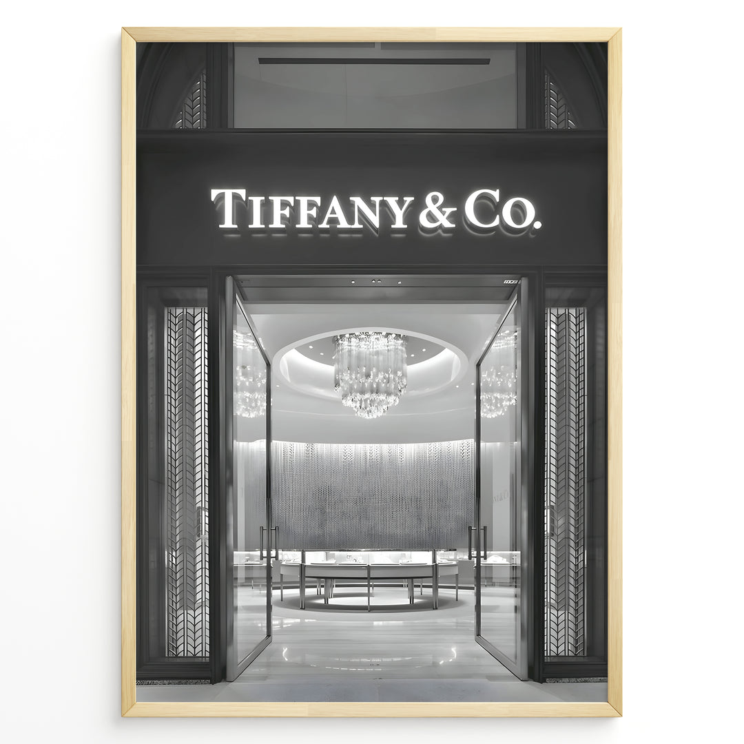 Fashion Plakat | Tiffany & Co. Entrance – Luxury Jewelry Store Poster in Black & White Plakaty.dk | Black and white photo of the Tiffany & Co. boutique entrance with glass doors, a chandelier inside, and the illuminated brand name above.