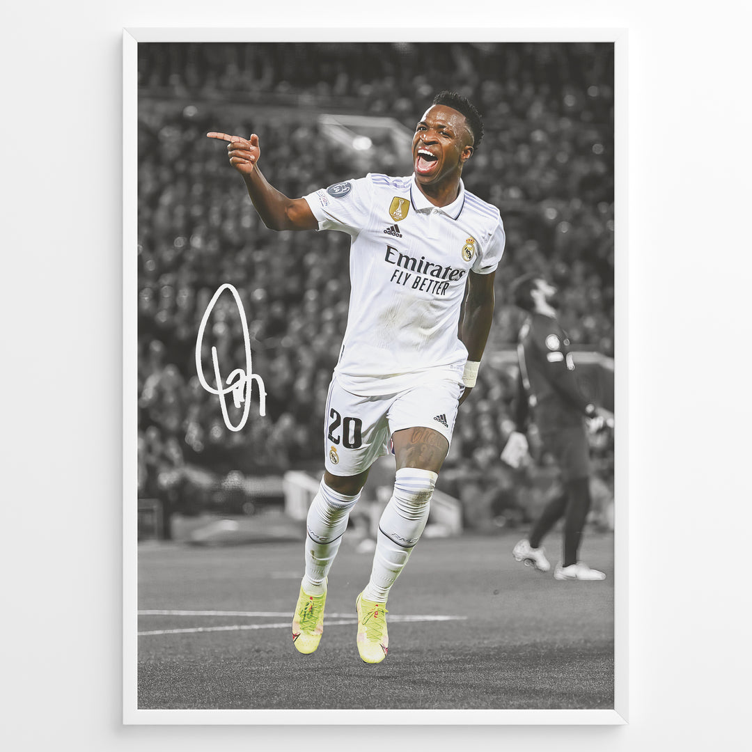 Framed plakat of Vinícius Jr. in a Real Madrid kit celebrating with a pointing gesture, color-highlighted against a black and white background with signature
