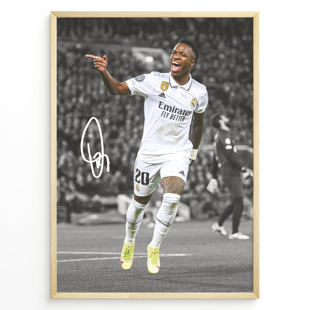 Framed plakat of Vinícius Jr. in a Real Madrid kit celebrating with a pointing gesture, color-highlighted against a black and white background with signature