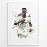 Load image into Gallery viewer, Framed watercolor-style plakat of Vinícius Jr. celebrating in a Real Madrid jersey with a gold artistic background
