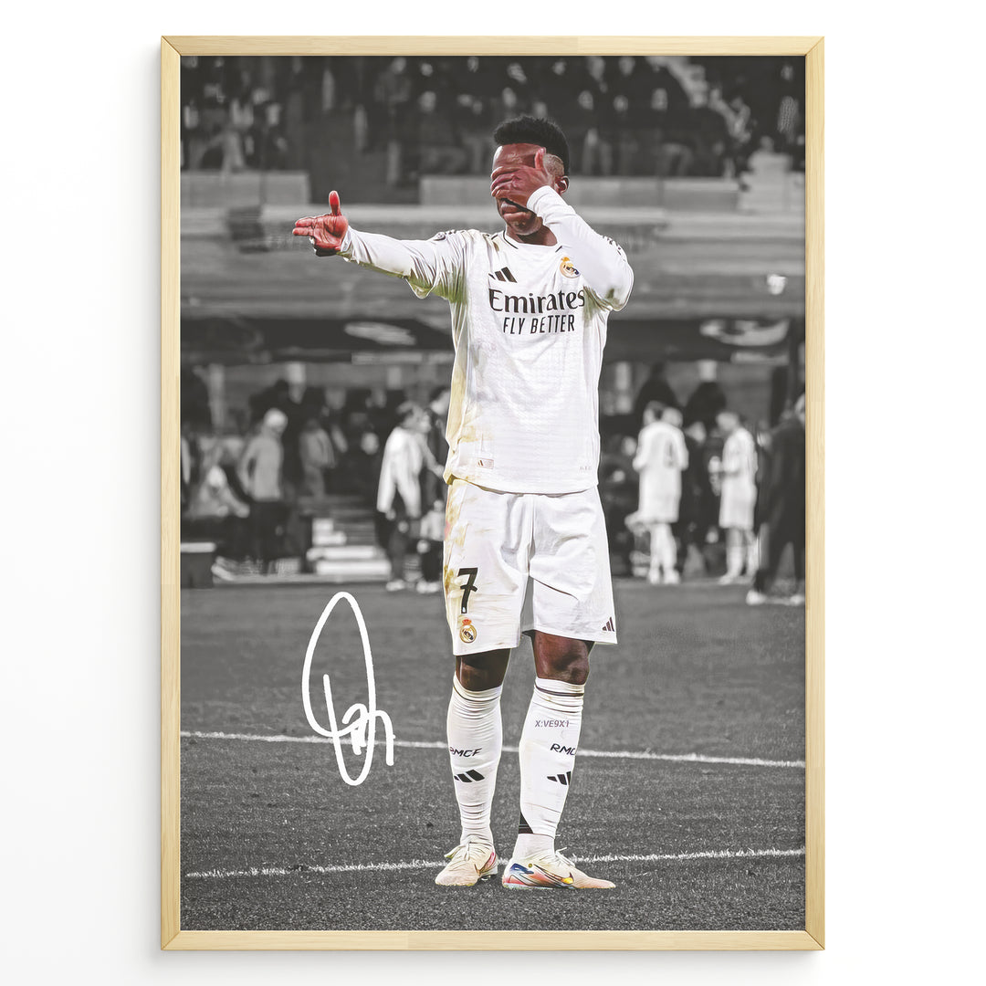 Framed plakat of Vinícius Jr. in a Real Madrid kit doing an eye-cover celebration, with a black and white background and printed signature