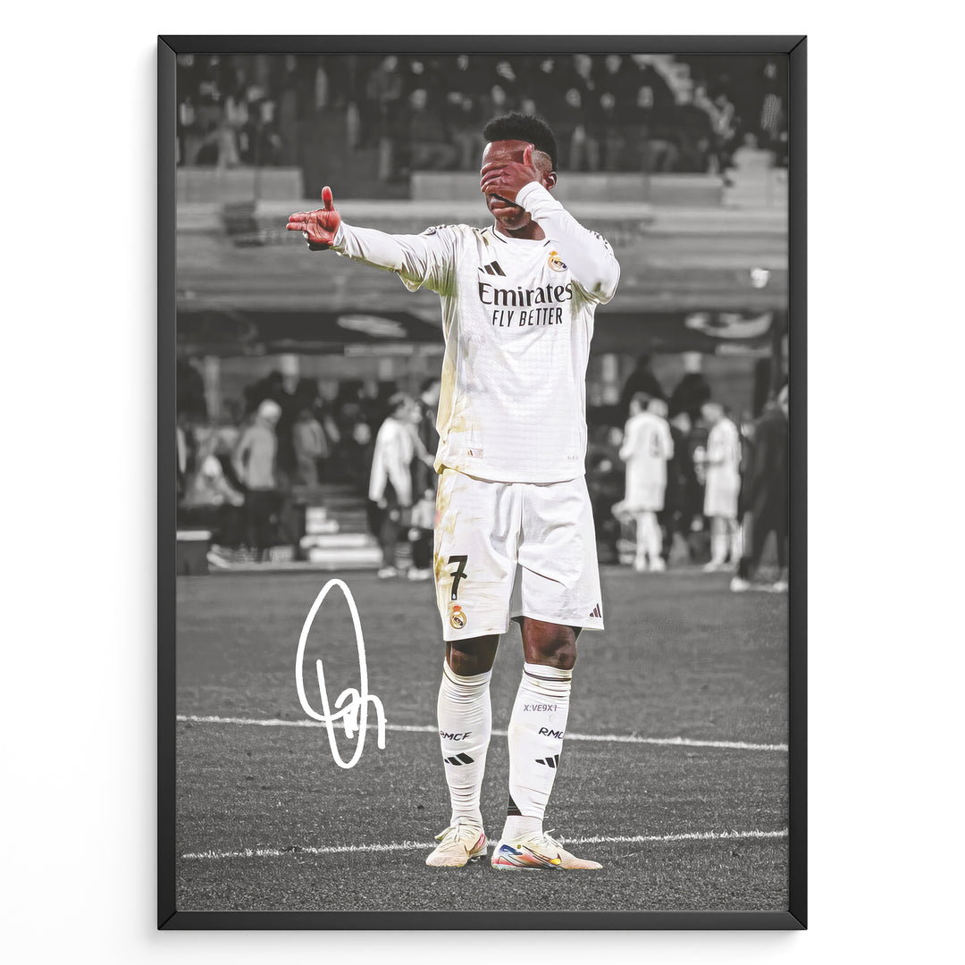 Framed plakat of Vinícius Jr. in a Real Madrid kit doing an eye-cover celebration, with a black and white background and printed signature