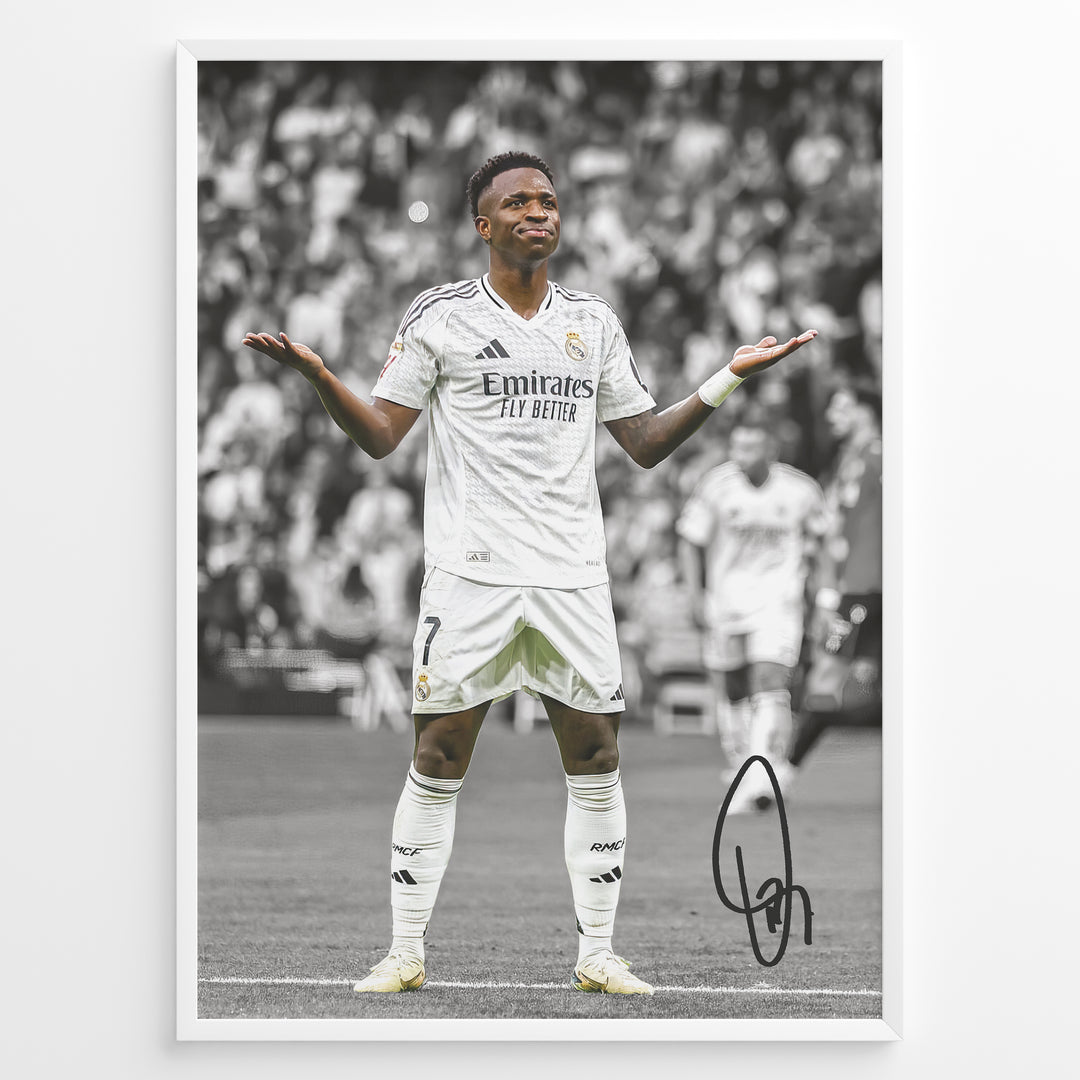 Framed Plakat of Vinícius Jr. in a Real Madrid kit doing a shrug celebration, with a black and white background and visible signature