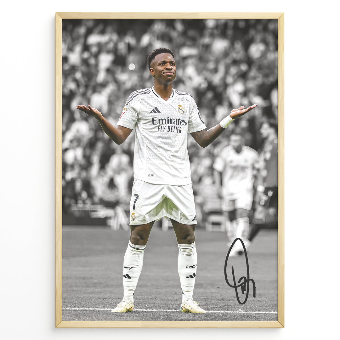 Framed Plakat of Vinícius Jr. in a Real Madrid kit doing a shrug celebration, with a black and white background and visible signature