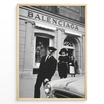 Load image into Gallery viewer, Fashion Plakat | Vintage Balenciaga Boutique – Paris Street Fashion Poster Plakaty.dk | Black and white photo of the Balenciaga boutique in Paris with a chauffeur, two stylish women, and a vintage car in the foreground.
