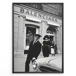 Load image into Gallery viewer, Fashion Plakat | Vintage Balenciaga Boutique – Paris Street Fashion Poster Plakaty.dk | Black and white photo of the Balenciaga boutique in Paris with a chauffeur, two stylish women, and a vintage car in the foreground.
